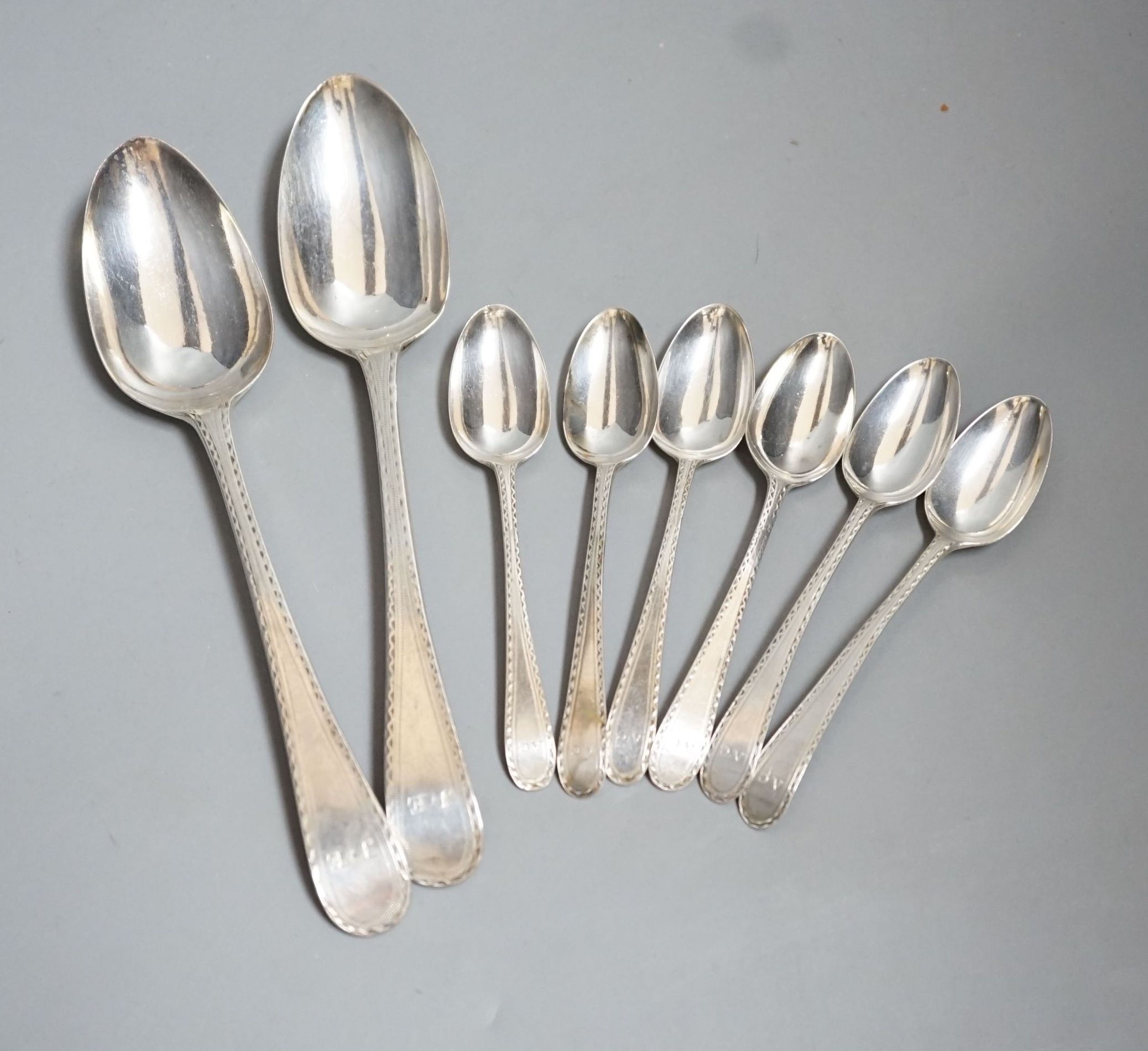 A set of silver George III bright cut engraved silver Old English pattern teaspoons, by Hester Bateman, no date letter and a pair of George III silver bright cut engraved Old English tablespoons, London, 1787